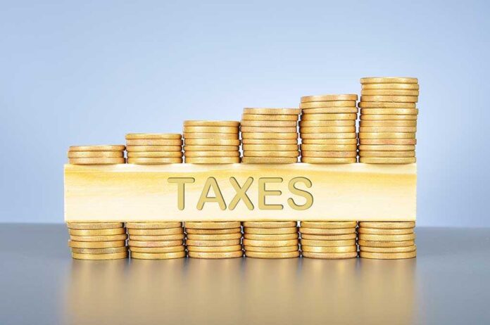 379014430 featured image Stacked coins with "TAXES" on block beneath.