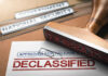 Declassified stamp on government document with paperclip