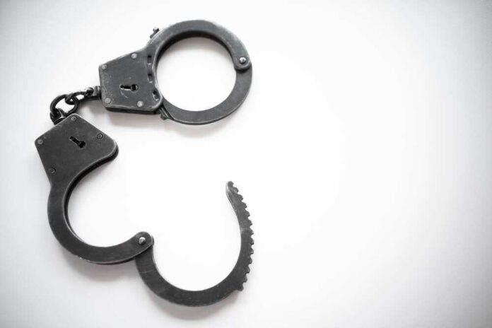 shutterstock_2116470560.jpg featured image Open metal handcuffs on white background.