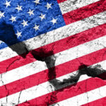 Cracked United States flag on textured surface.