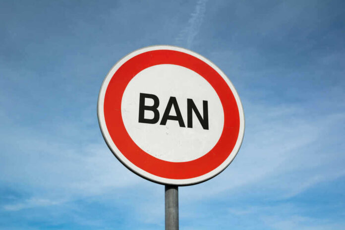 shutterstock_17592636891.jpg featured image Traffic sign reads BAN against blue sky.