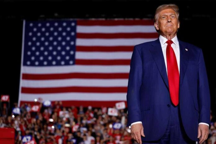 shutterstock_2543529699.jpg featured image Donald Trump in suit stands before large American flag