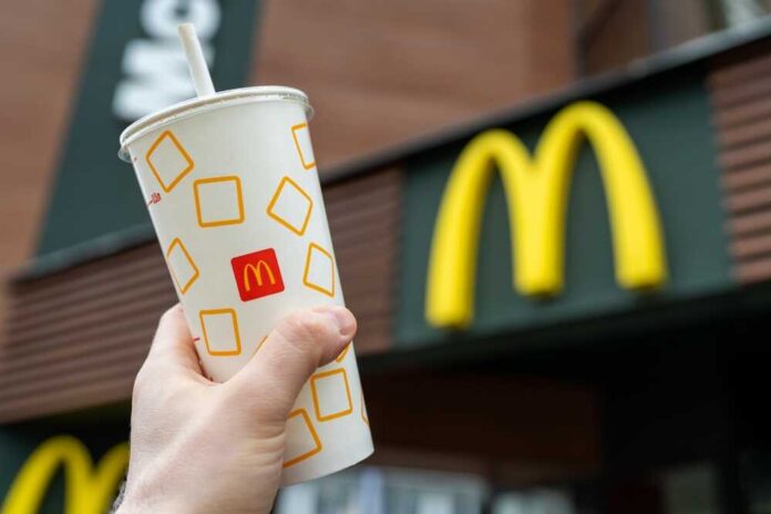 shutterstock_2161712859.jpg featured image Hand holding McDonalds cup in front of sign