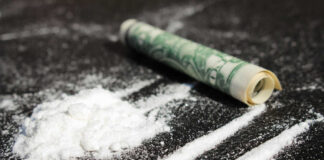 Cocaine lines with rolled banknote on surface