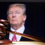 DEVELOPING: Judge Stops Trump Gavel in foreground with blurry man in background.