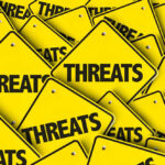 Chilling Trump Threat Sparks Police Crackdown Yellow signs with the word threats overlapping