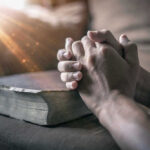 STUNNING Temple Mount Discovery Changes Everything Hands praying over a Bible with sunlight