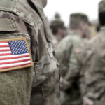US soldiers in camouflage uniforms with American flag patch