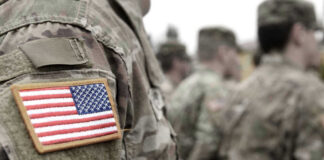 US soldiers in camouflage uniforms with American flag patch