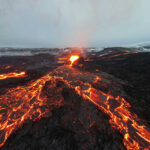 Volcano Goddess Unleashes Molten Fury Lava flowing from volcanic eruption under gray sky