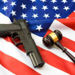 JUST IN: Gun Law CRUMBLES — Court Drops HUGE Ruling Gun and gavel on a US flag