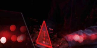 Warning symbol over laptop with user