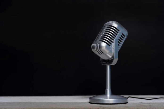 Silver vintage microphone against a black background