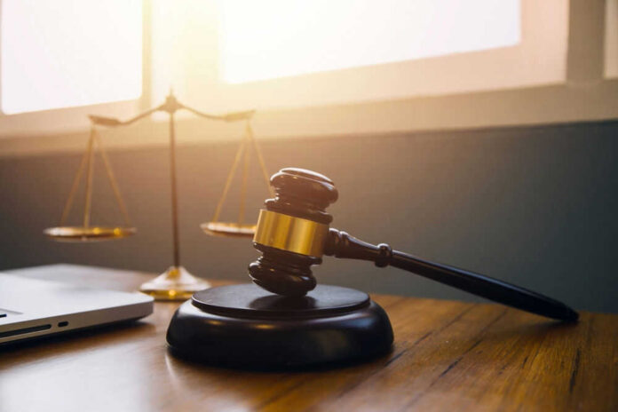 shutterstock_2347797923.jpg Gavel and scales of justice on desk