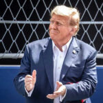 TRUMP UNLEASHES $26 Million Bounty Hunt Donald Trump clapping, wearing suit.