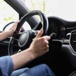 Engine Nightmare: Million Drivers at Risk? Hands gripping a steering wheel inside a car