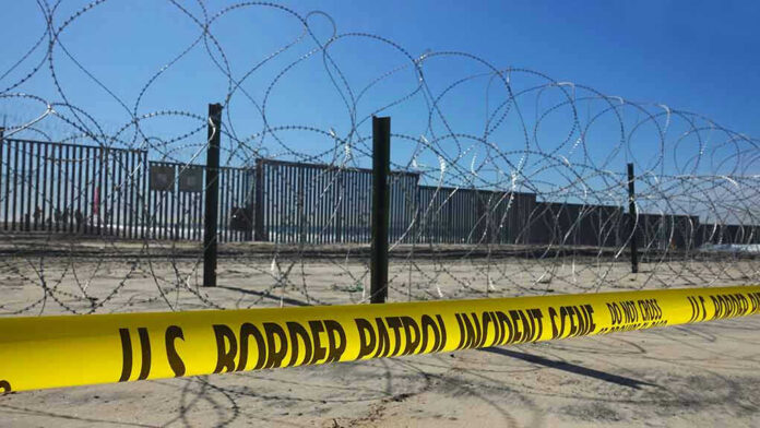 Border patrol tape and barbed wire fence