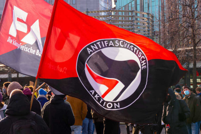 Protest with Antifascist Action flags and people outdoors