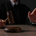 Judicial Assassin: Judge Commits Cold-Blooded Murder Judge holding gavel, hand raised in courtroom