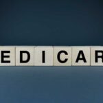 AI Denial Nightmare Hits Medicare Wooden blocks spelling out 'MEDICARE' on a dark background