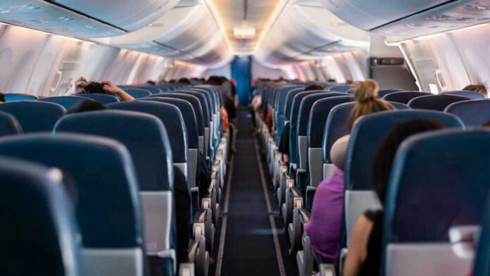 Airplane interior with passengers seated mid-flight