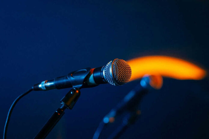 Close-up of a microphone on a stand, dark background