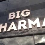 Trump FORCES Pharma Giant Into Surrender Sign displaying the words BIG PHARMA on a glass building