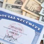 A social security card placed on top of various denominations of U.S. currency