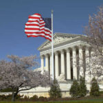 TODAY: Supreme Court Showdown US Supreme Court building with an American flag and cherry blossom trees