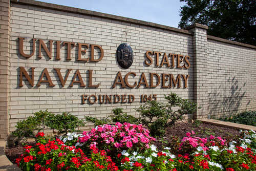 Sign of the United States Naval Academy with flowers in front