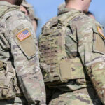 Soldiers in camouflage uniforms with American flag patches
