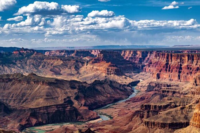 A panoramic view of the Grand Canyon with a river winding through the landscape