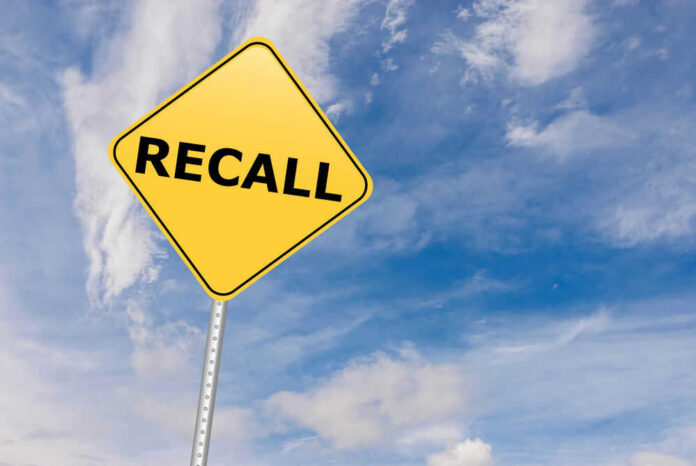 Yellow sign with RECALL text against blue sky.