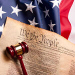 Judge Creates Constitutional CRISIS Over Troops Gavel on U.S. Constitution with American flag.
