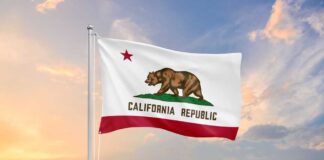 California state flag waving against a sunset sky