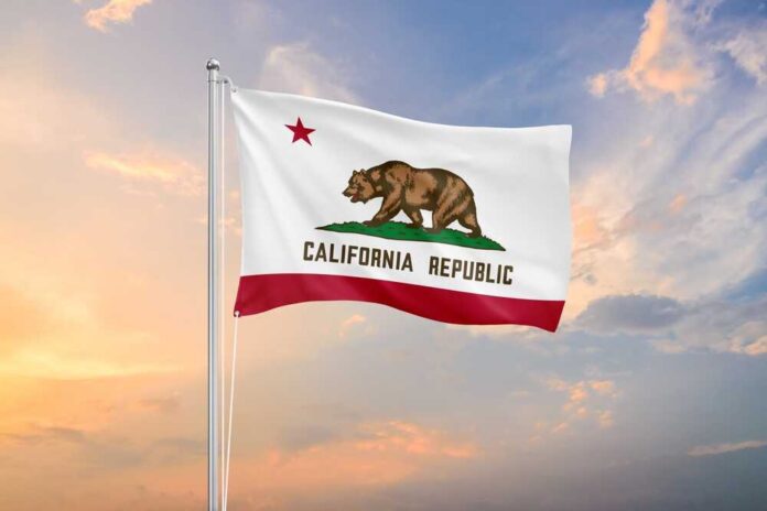 California state flag waving against a sunset sky