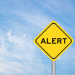 ALARMING Discovery Forces Trump Route Change Yellow alert sign against a blue sky