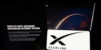 A smartphone displaying the Starlink logo in front of a screen showing a space image