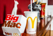 A Big Mac box and a McDonald's drink on a wooden table
