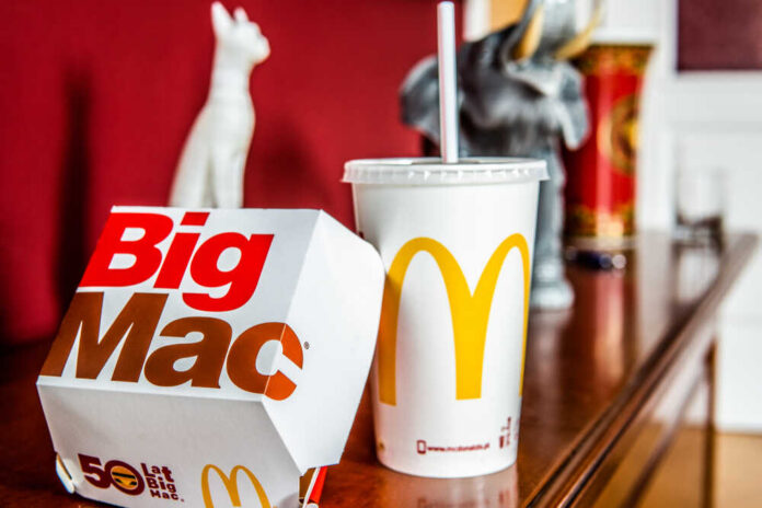 A Big Mac box and a McDonald's drink on a wooden table