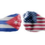 Two fists painted with Cuban and American flags.