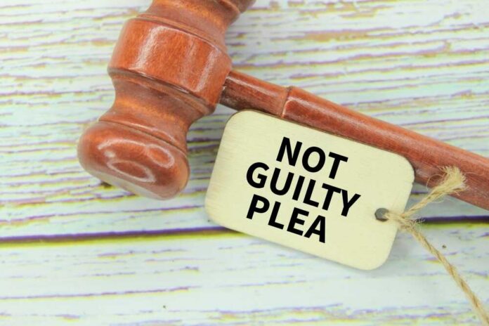 A wooden gavel next to a tag that reads NOT GUILTY PLEA