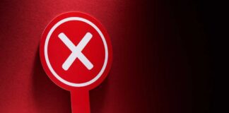 Red sign with a white 'X' symbol against a dark background