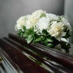 Mike Tyson’s Sister DEAD at 25 — He’s Fighting Back A floral arrangement of white roses and greenery on a polished casket