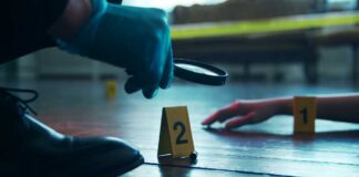 A detective examining evidence at a crime scene with markers on the floor