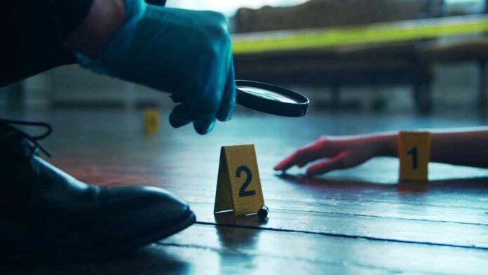 A detective examining evidence at a crime scene with markers on the floor