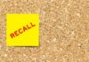 Yellow sticky note with the word 'RECALL' on a corkboard