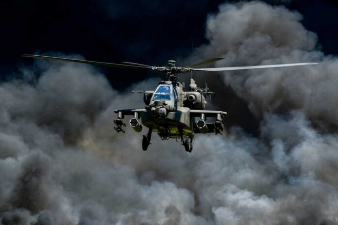 shutterstock_2596364389.jpg Military helicopter flying through a cloud of smoke