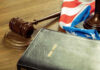 Gavel, Holy Bible, and American flag on a desk.