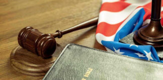 Gavel, Holy Bible, and American flag on a desk.
